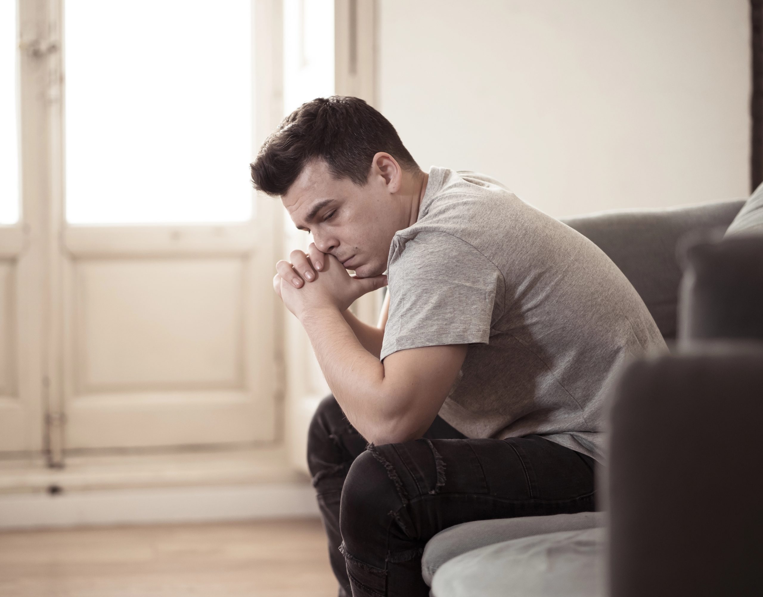 Unhappily married man with Miserable Husband Syndrome sitting at home